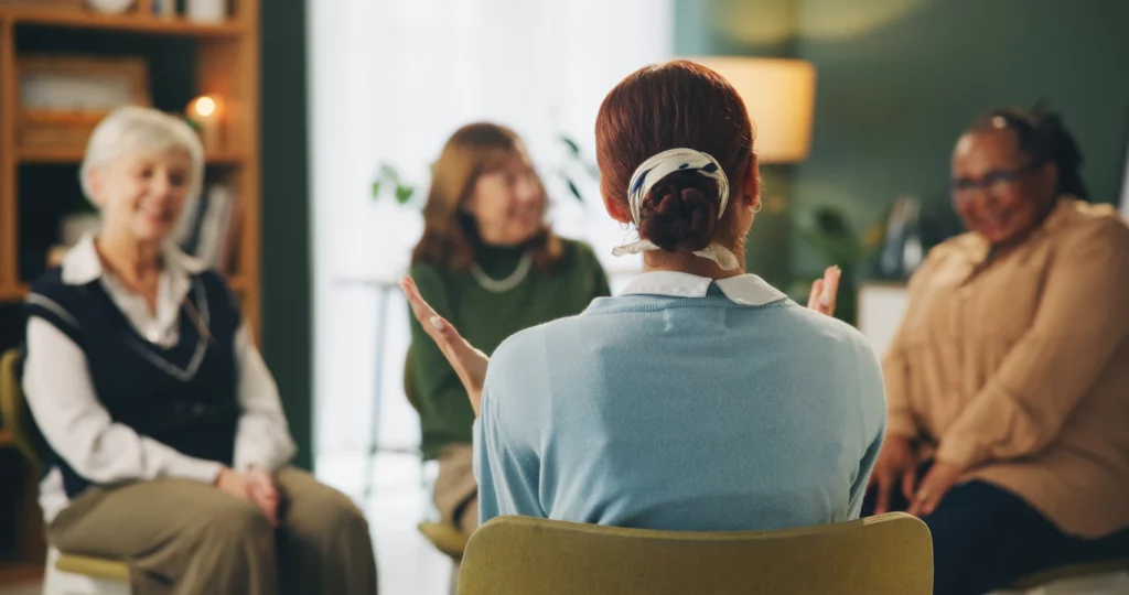 Group of women seated in a circle having a conversation during a support session